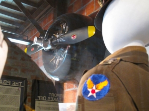 The empty gaze of a WW2 pilot's dress uniform gives the engine of the T6 trainer plane one last inspection.