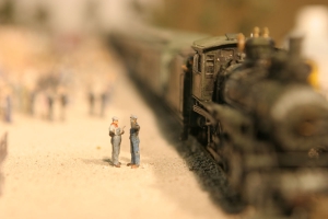 A coal shoveler wipes the sweat from his brow as the engineer regales him with an anecdote in this HO scale model created by AST Exhibits.