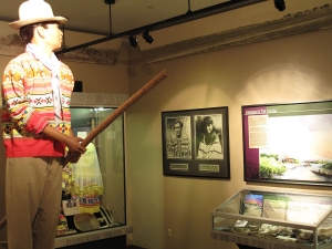A Seminole glides through the Native People's Room standing atop his dugout canoe.